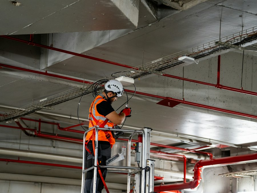Technician on a lift installing equipment in a ceiling